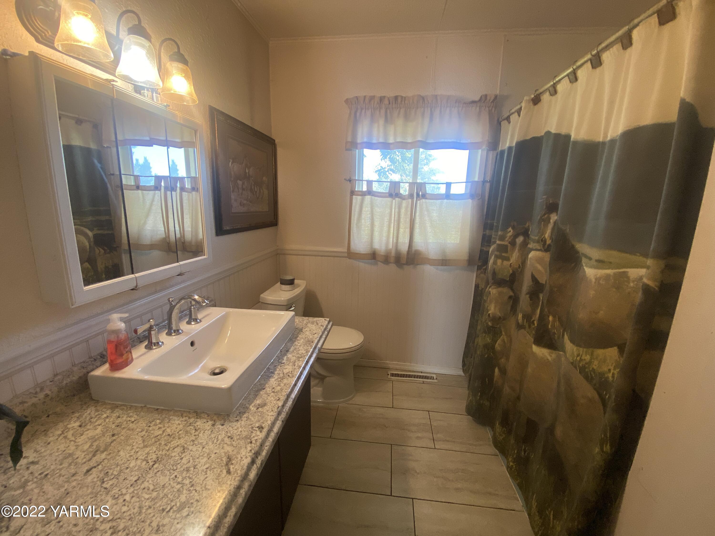 91 Arrowsmith Road Sunnyside, WA 98944 - Photo 15 of 19 a bathroom with a granite countertop sink a mirror and shower