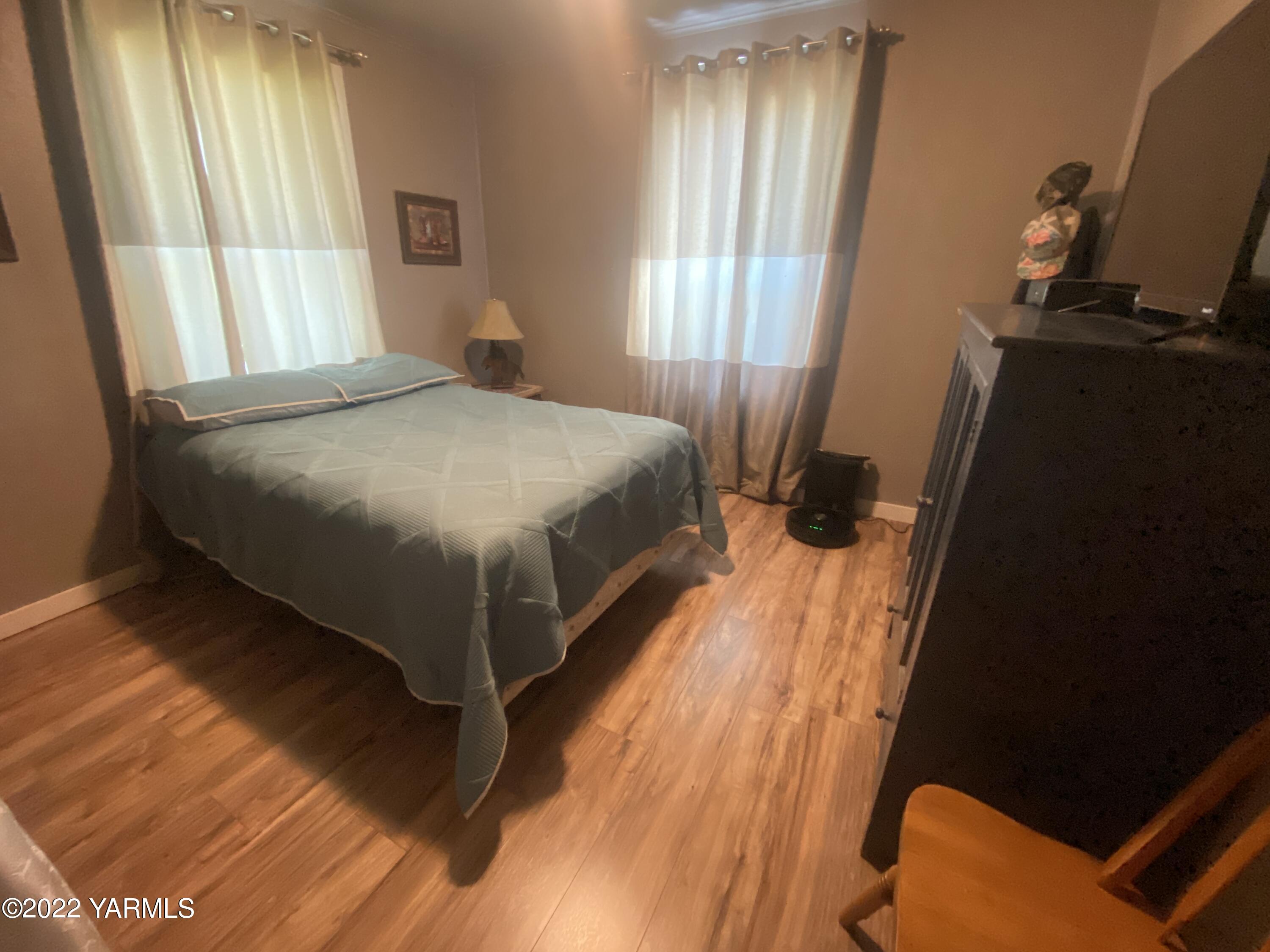 91 Arrowsmith Road Sunnyside, WA 98944 - Photo 10 of 19 a bedroom with a bed and wooden floor