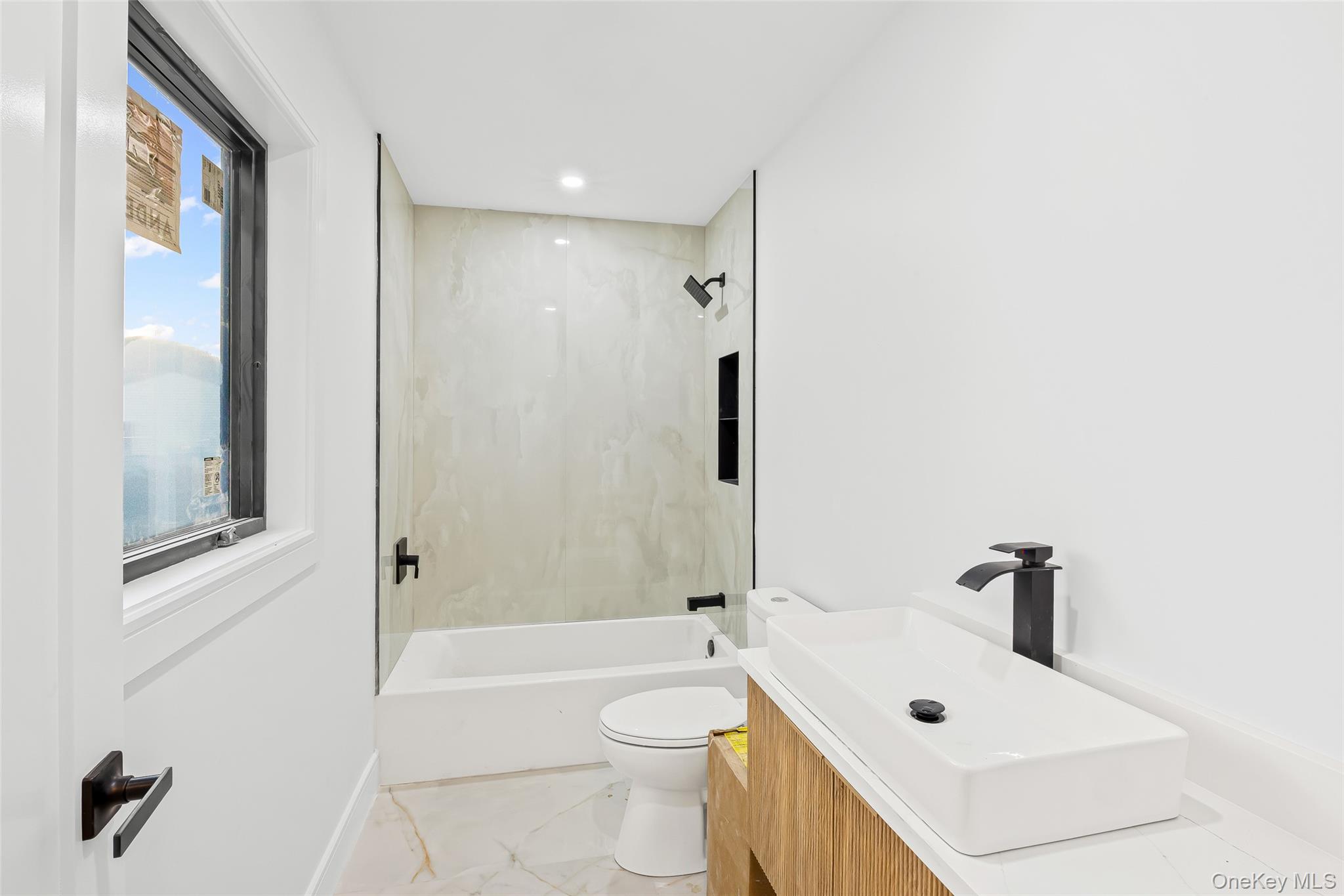 26 Tremont Avenue Patchogue, NY 11772 - Photo 22 of 50 a bathroom with a sink a toilet and shower