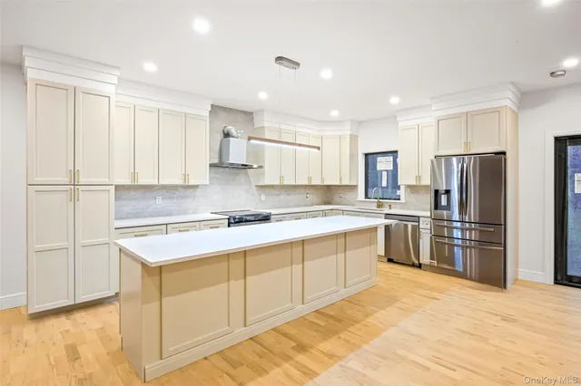 a kitchen with stainless steel appliances granite countertop a refrigerator sink and white cabinets