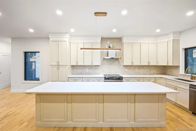 a large kitchen with stainless steel appliances kitchen island granite countertop a refrigerator and cabinets
