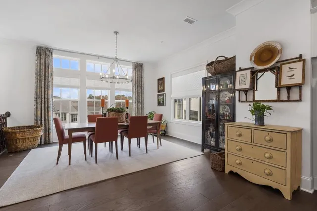 a view of a dining room with furniture a chandelier and wooden floor