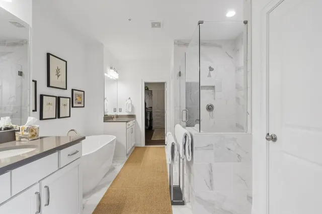 a spacious bathroom with a double vanity sink a mirror a bathtub and shower