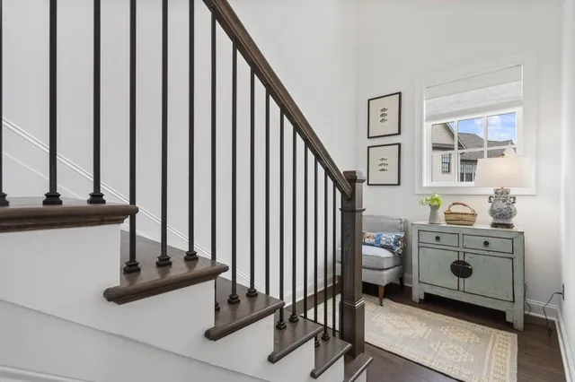 a view of a hallway with wooden floor windows and stairs