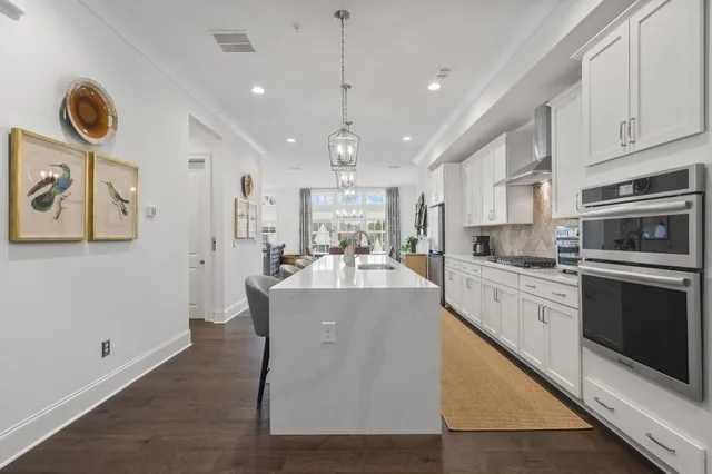 a kitchen with stainless steel appliances granite countertop a stove a sink a oven a dining table and chairs