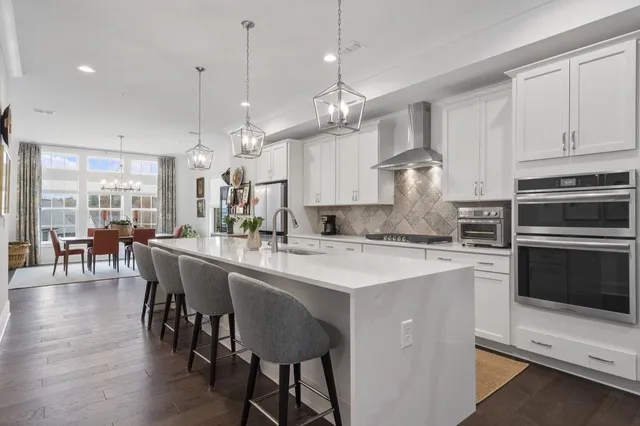 a large kitchen with stainless steel appliances a large center island attached withe living room