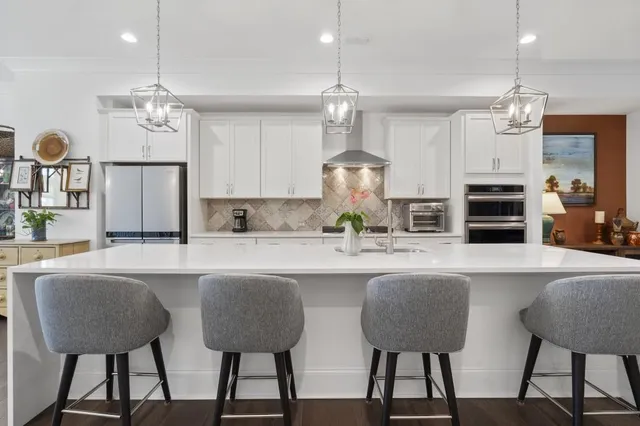 a kitchen with refrigerator a sink and chairs