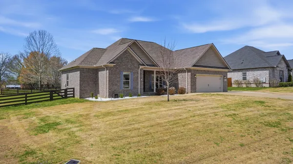 a front view of a house with a garden and yard