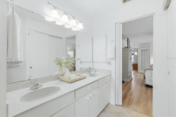 a bathroom with a double vanity sink mirror and shower