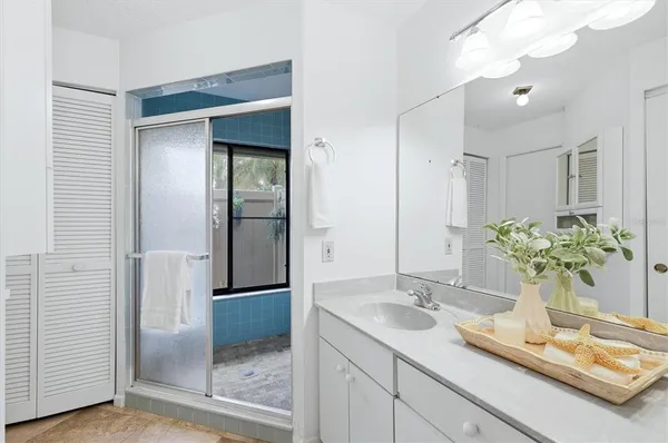 a bathroom with a granite countertop sink a mirror and a shower