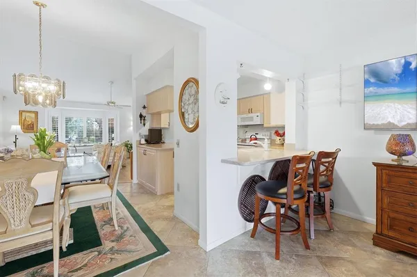 a view of a dining room and livingroom with furniture a rug a chandelier and wooden floor