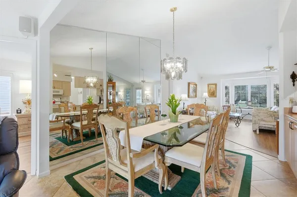a view of a dining room and livingroom with furniture wooden floor a chandelier