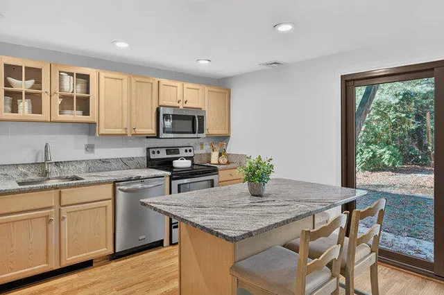 a kitchen with granite countertop kitchen island cabinets and wooden floor