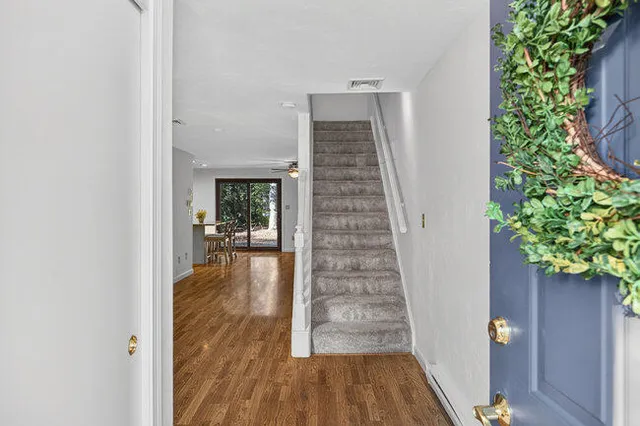 a view of a hallway with wooden floor and a potted plant