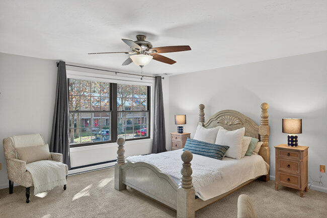 195 Falmouth Road, Unit 10E Mashpee, MA 02649 - Photo 26 of 33 a bedroom with a large bed and a chandelier