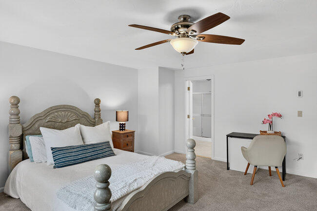 195 Falmouth Road, Unit 10E Mashpee, MA 02649 - Photo 27 of 33 a bedroom with a bed and a chandelier