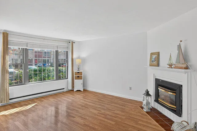a view of empty room with wooden floor and fireplace