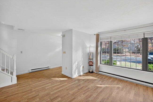 195 Falmouth Road, Unit 10E Mashpee, MA 02649 - Photo 5 of 33 a view of empty room with wooden floor and fan
