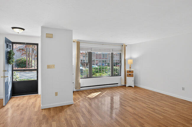 195 Falmouth Road, Unit 10E Mashpee, MA 02649 - Photo 9 of 33 an empty room with wooden floor and windows
