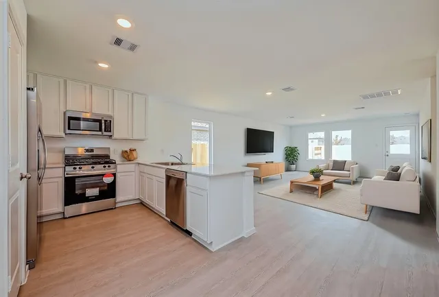 a kitchen with sink a microwave and cabinets