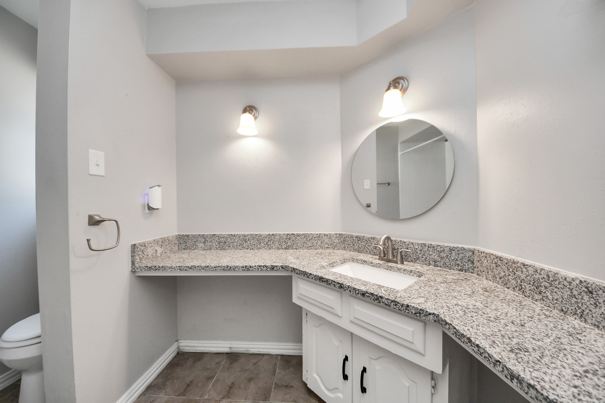 7303 Foxwick Lane Humble, TX 77338 - Photo 18 of 38 a bathroom with a granite countertop sink a toilet and a mirror