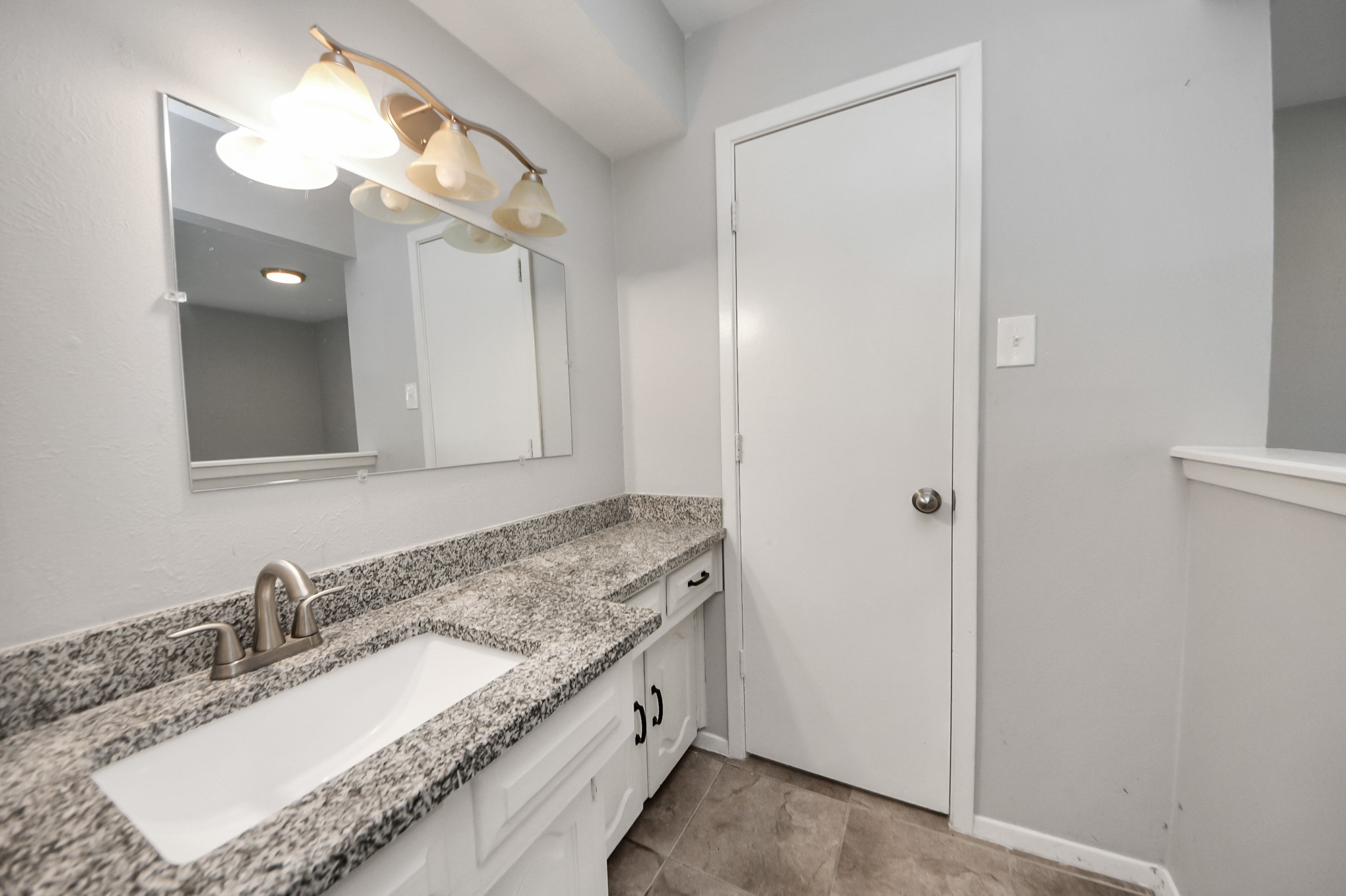7303 Foxwick Lane Humble, TX 77338 - Photo 22 of 38 a bathroom with a granite countertop double vanity sink and a mirror