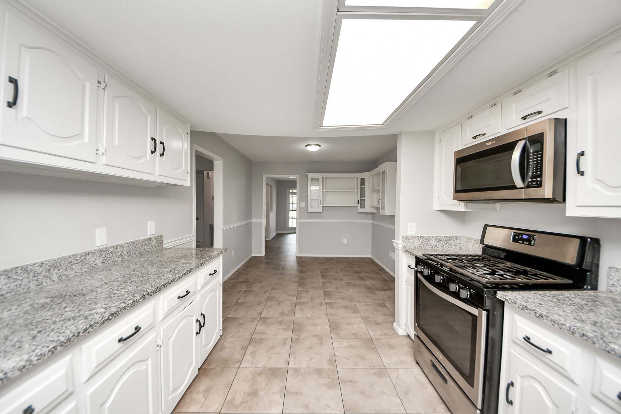 7303 Foxwick Lane Humble, TX 77338 - Photo 28 of 38 a kitchen with stainless steel appliances granite countertop a stove a sink and a microwave