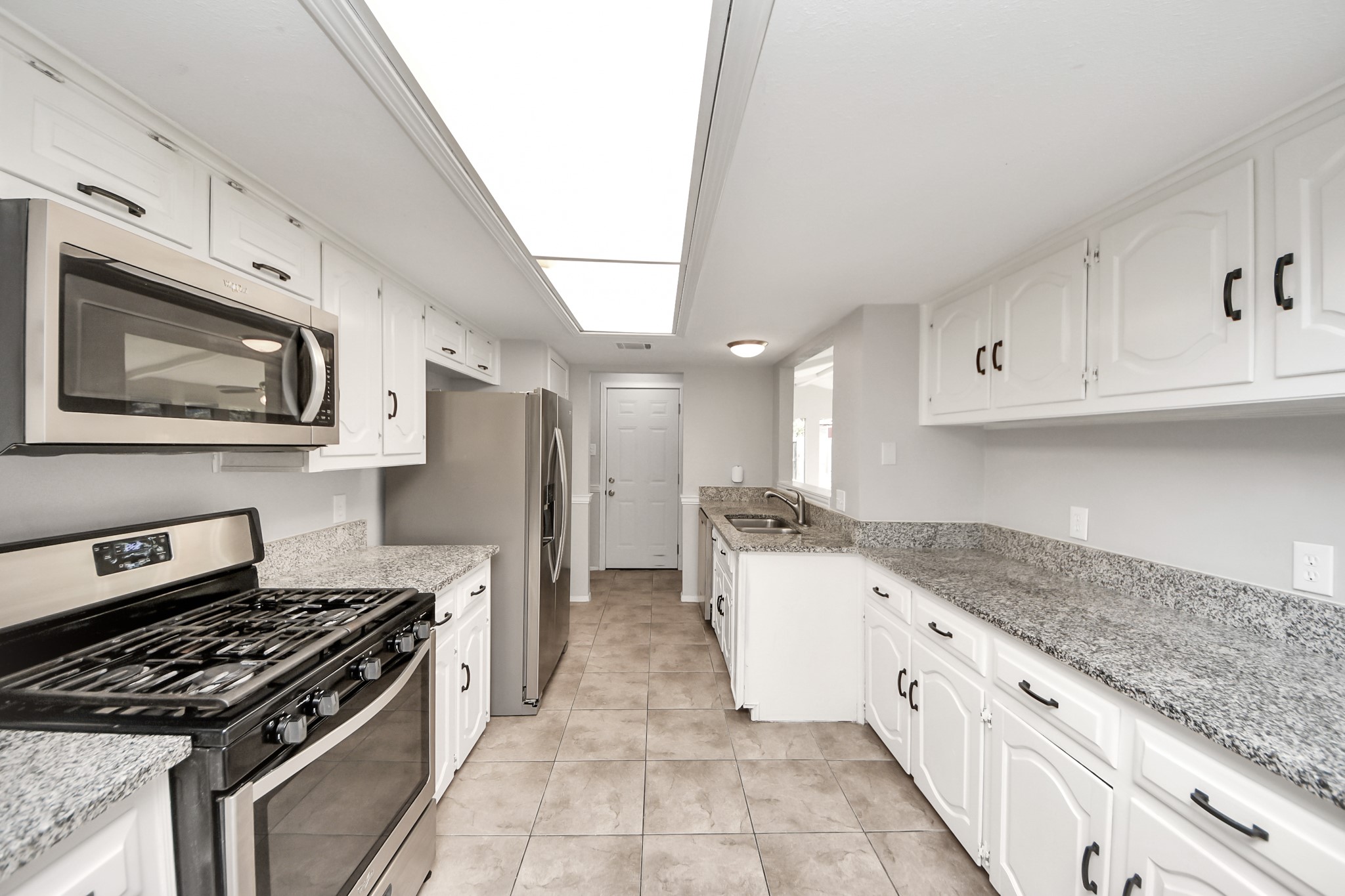 7303 Foxwick Lane Humble, TX 77338 - Photo 32 of 38 a kitchen with granite countertop cabinets stainless steel appliances and a counter space