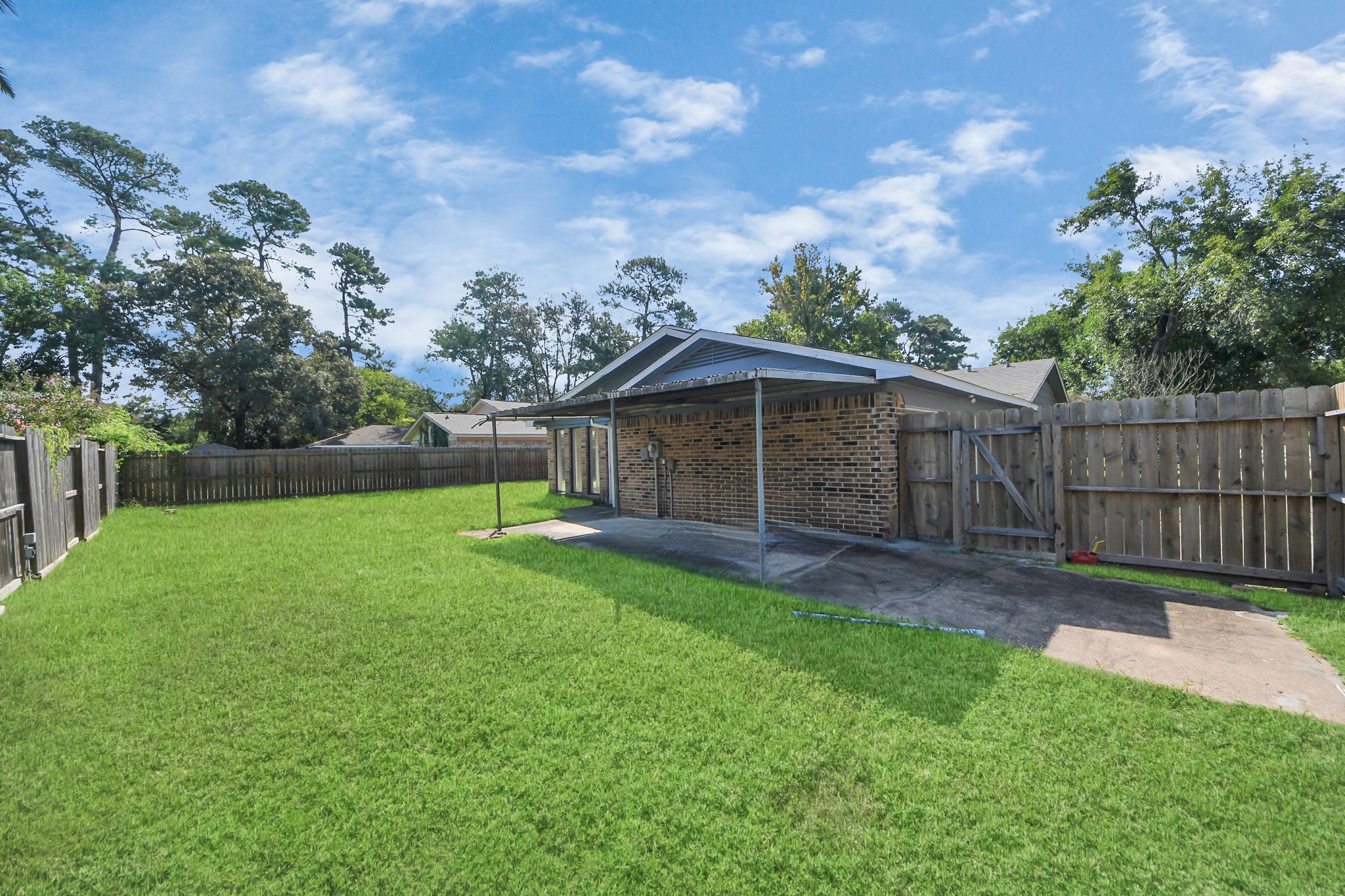 7303 Foxwick Lane Humble, TX 77338 - Photo 36 of 38 a view of a backyard with a barbeque and wooden fence