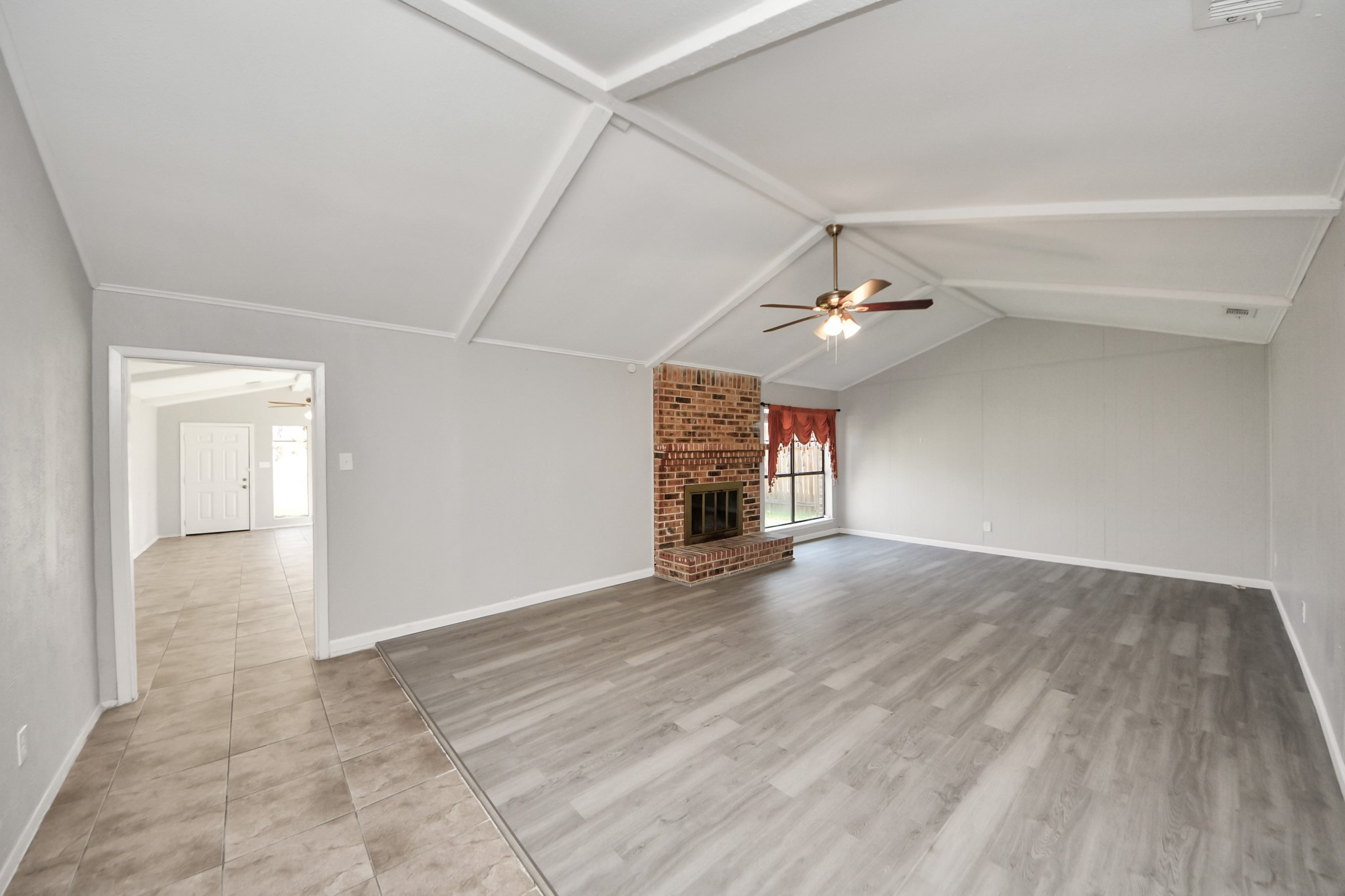 7303 Foxwick Lane Humble, TX 77338 - Photo 10 of 38 an empty room with wooden floor chandelier fan and windows