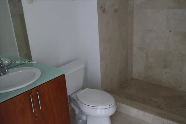 a white toilet sitting next to a bathroom sink