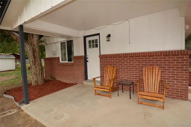 a view of a patio with table and chairs with wooden fence