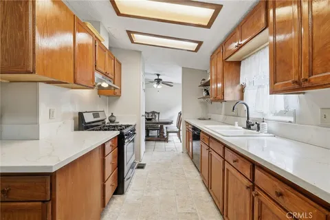 a kitchen with stainless steel appliances granite countertop a sink a stove and a refrigerator