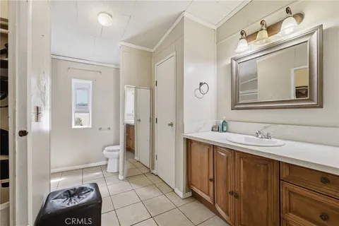 a bathroom with a toilet a sink a vanity and mirror