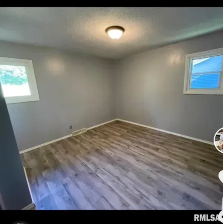 a view of room with wooden floor and windows