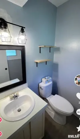 a bathroom with a toilet sink and mirror