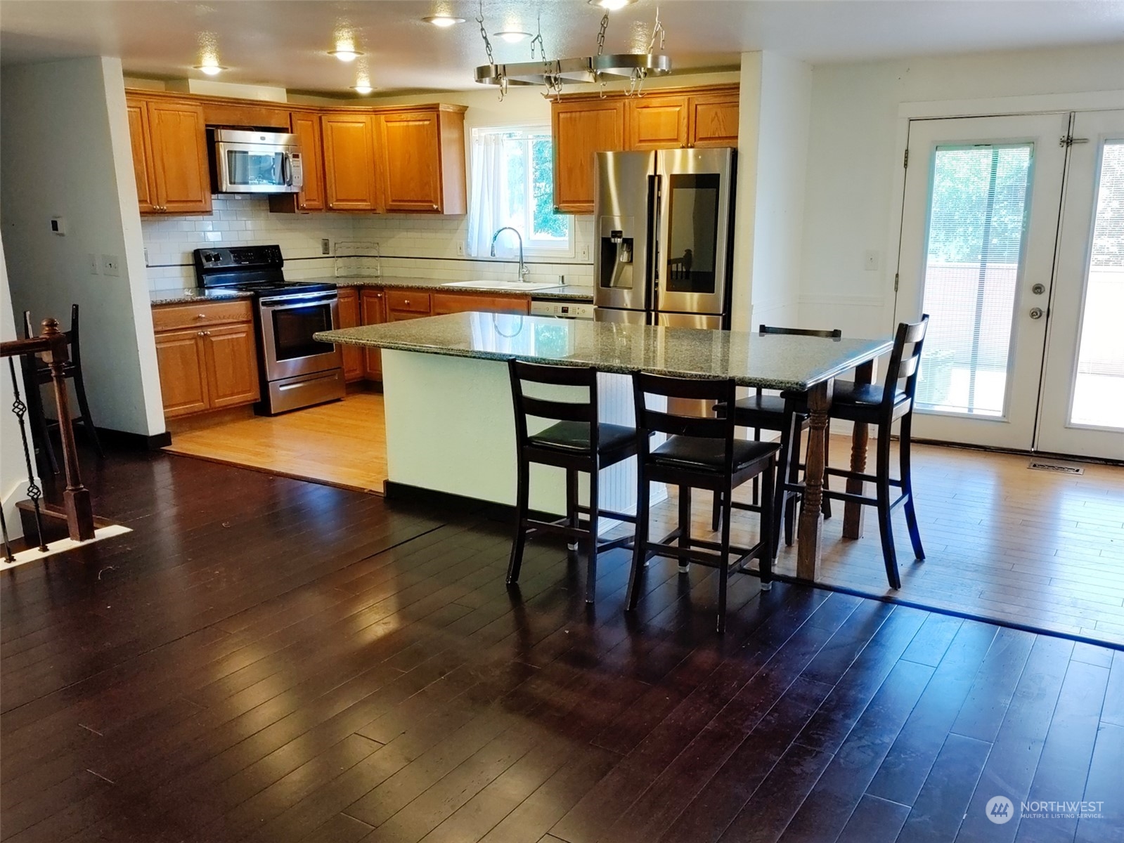 16032 Spanaway Loop Road South Spanaway, WA 98387 - Photo 4 of 28 a kitchen with stainless steel appliances wooden floors and wooden cabinets