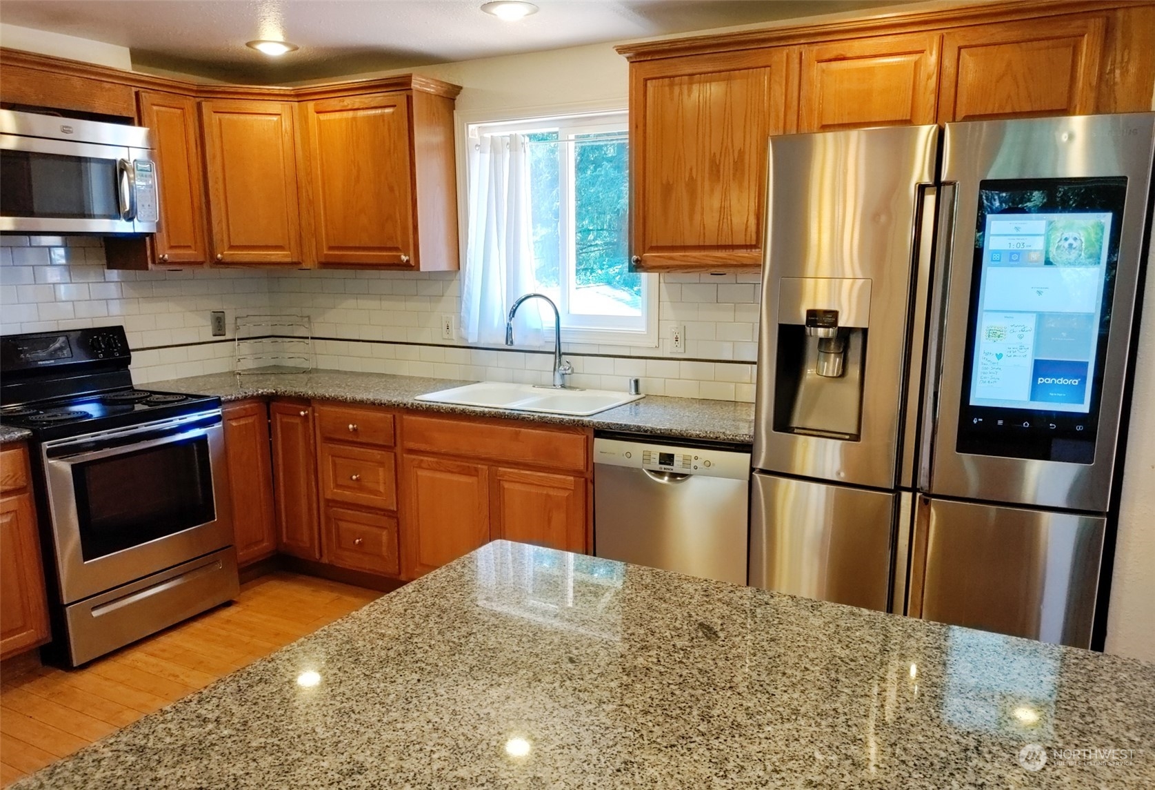 16032 Spanaway Loop Road South Spanaway, WA 98387 - Photo 6 of 28 a kitchen with stainless steel appliances granite countertop a refrigerator stove and microwave