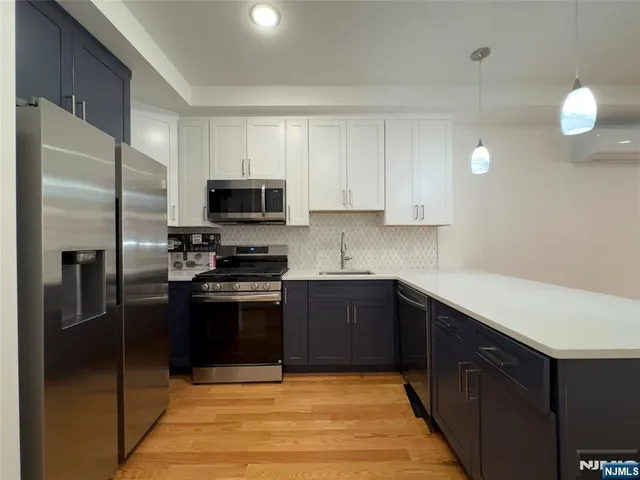 a kitchen with stainless steel appliances granite countertop a refrigerator stove and microwave