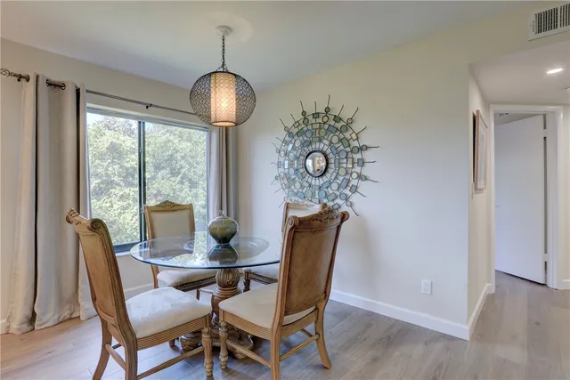 a dining room with furniture a chandelier and wooden floor