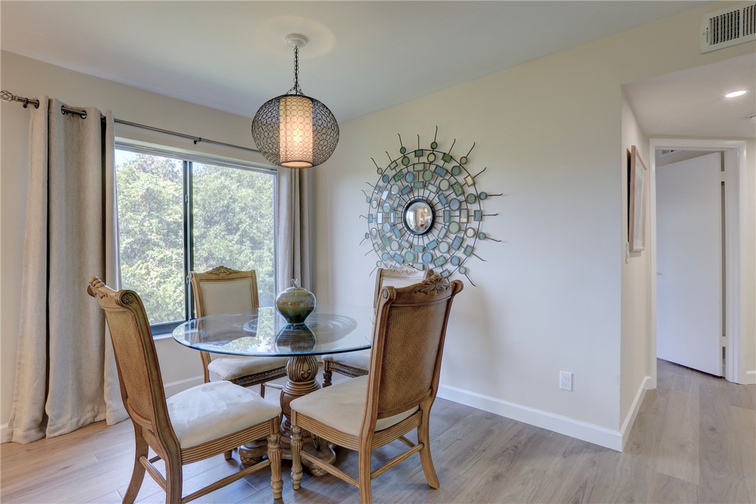 9612 Riverside Drive, Unit 102 Sebastian, FL 32958 - Photo 11 of 32 a dining room with furniture a chandelier and wooden floor