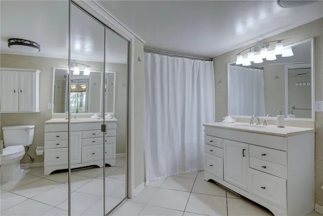 a bathroom with a double vanity sink mirror and toilet