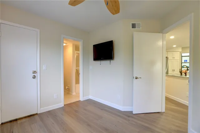 a view of a livingroom with wooden floor and a flat screen tv
