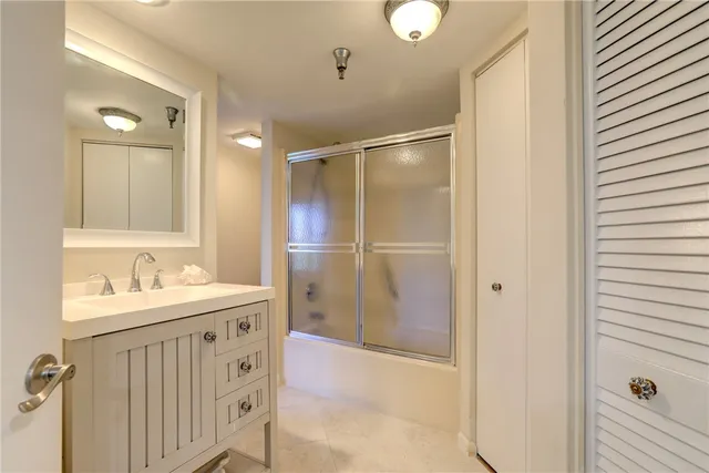 a bathroom with a sink mirror and shower