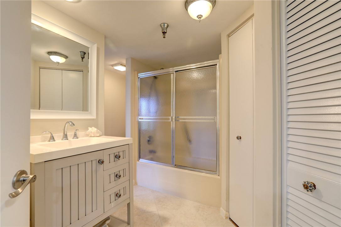9612 Riverside Drive, Unit 102 Sebastian, FL 32958 - Photo 23 of 32 a bathroom with a sink mirror and shower