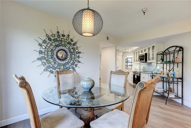 a dining room with furniture a chandelier and wooden floor