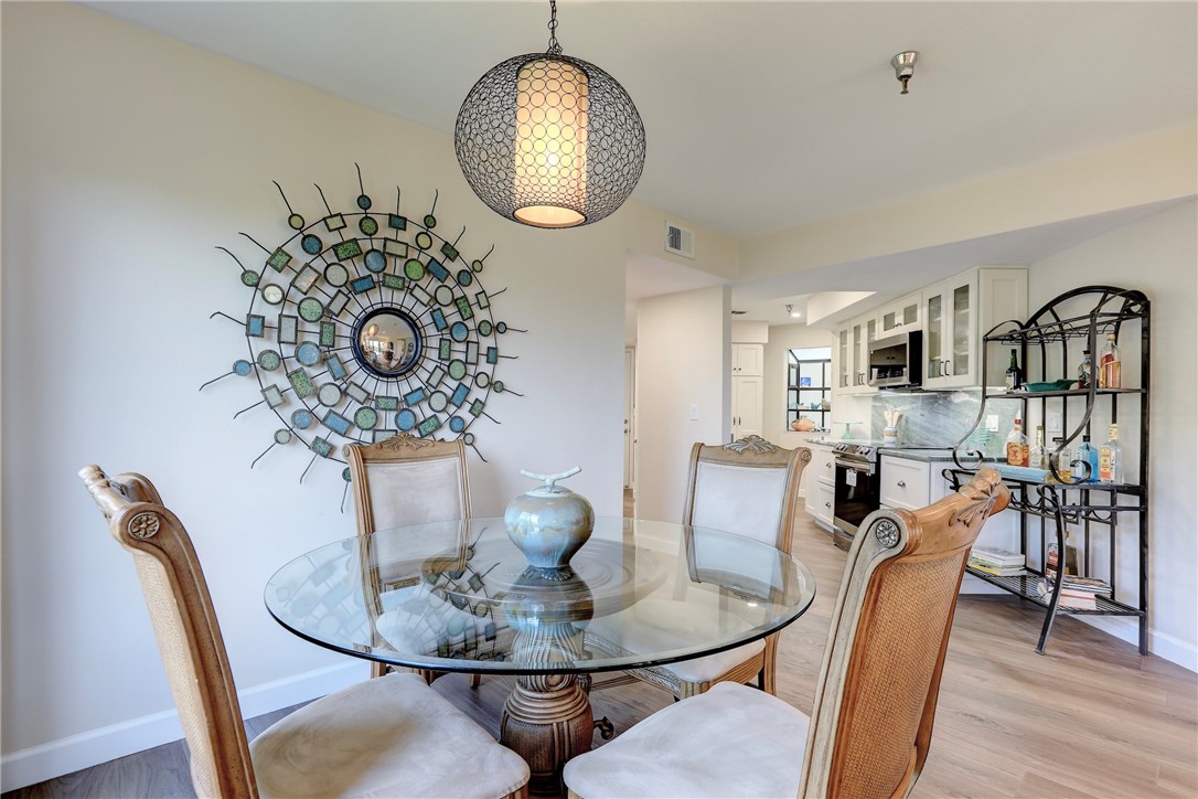 9612 Riverside Drive, Unit 102 Sebastian, FL 32958 - Photo 10 of 32 a dining room with furniture a chandelier and wooden floor