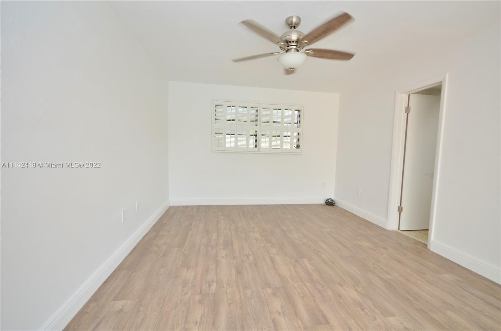 6760 Royal Melbourne Drive Hialeah, FL 33015 - Photo 18 of 36 an empty room with a window and a ceiling fan
