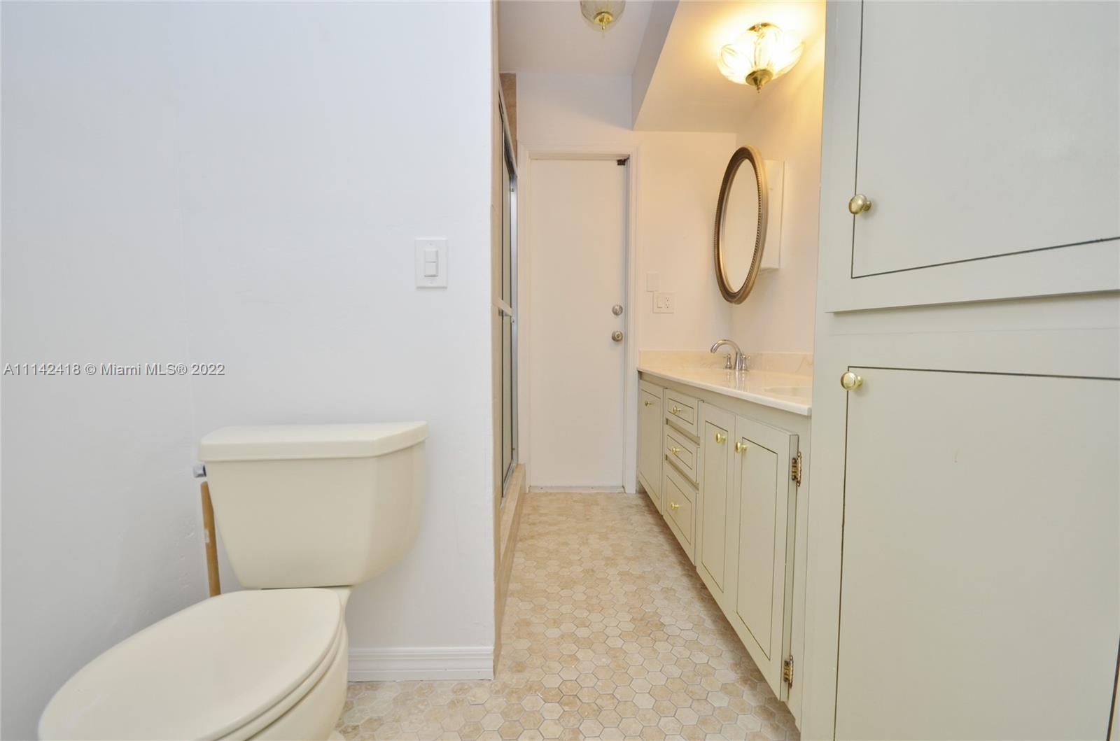 6760 Royal Melbourne Drive Hialeah, FL 33015 - Photo 19 of 36 a bathroom with a toilet sink and mirror