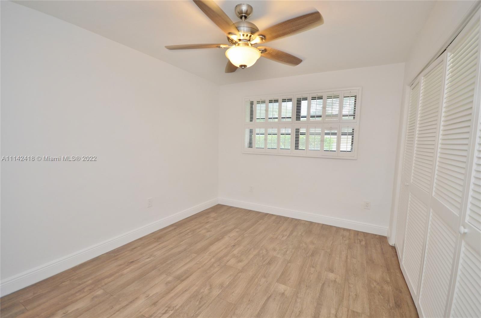 6760 Royal Melbourne Drive Hialeah, FL 33015 - Photo 29 of 36 wooden floor in an empty room with a window